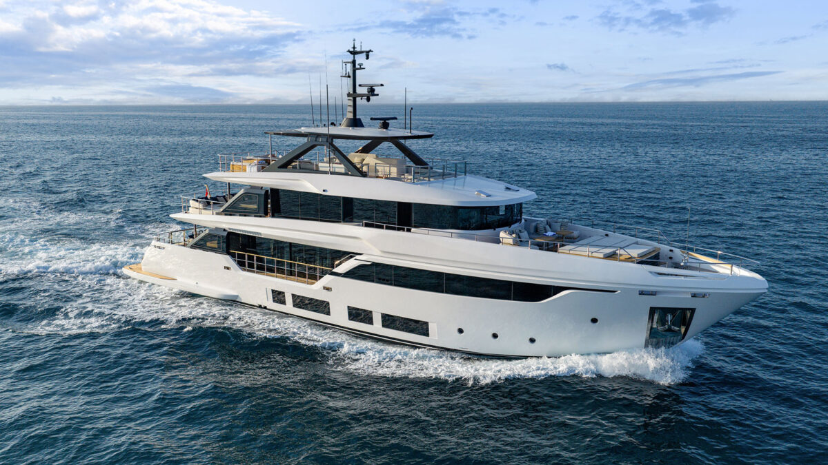 A large white superyacht with multiple decks cruises across open blue water, leaving a wake.