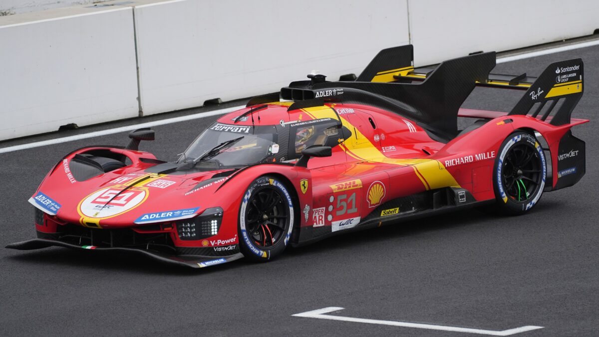 A red and yellow Ferrari 499P No.51 endurance race car on a racetrack.