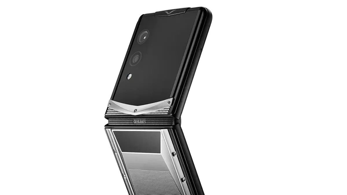 A black and silver Vertu foldable phone shown open beside a matching smart ring on a white background.