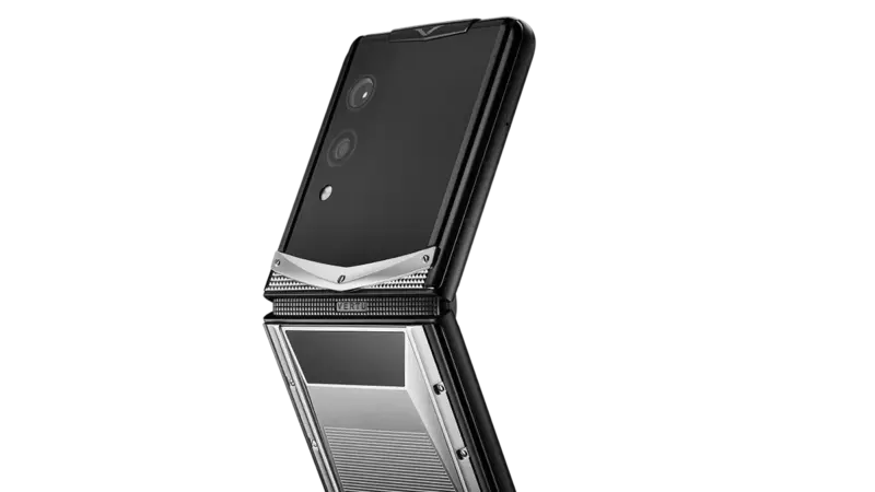 A black and silver Vertu foldable phone shown open beside a matching smart ring on a white background.