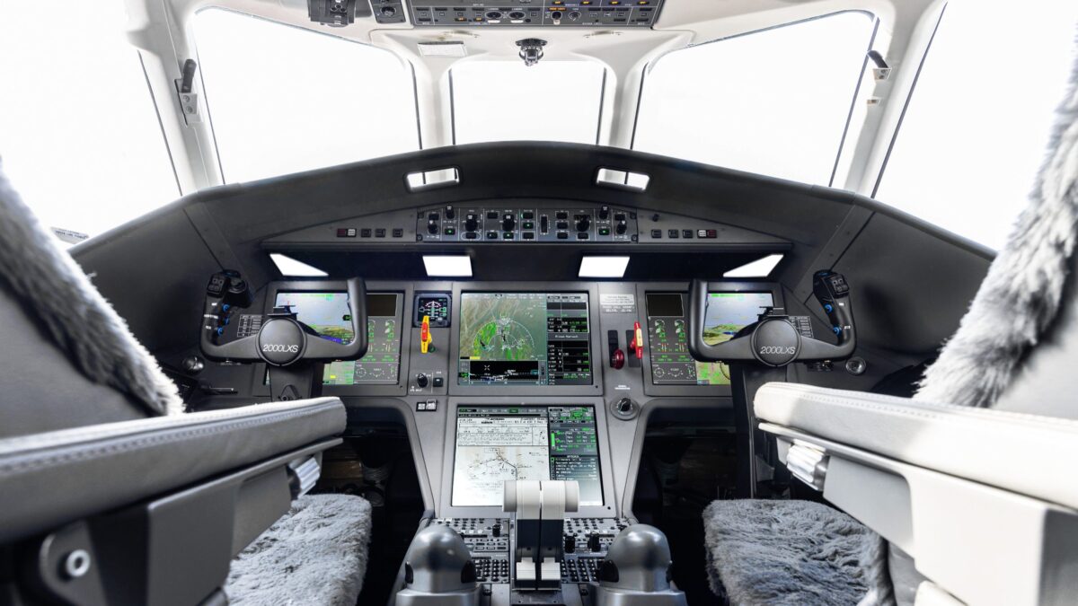 Cockpit interior of a Dassault Falcon 2000 jet showing avionics displays and control yokes labeled 2000LXS.
