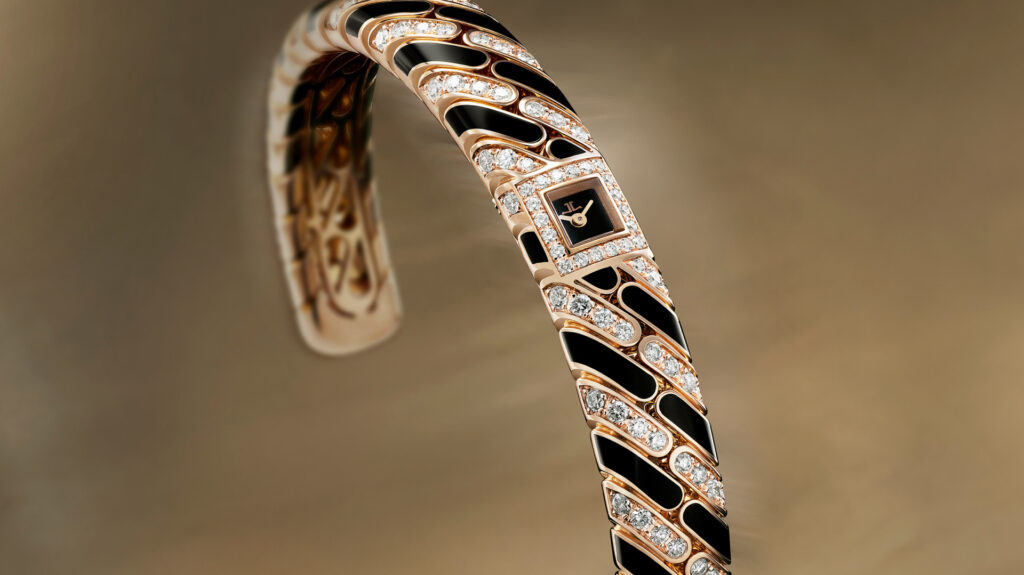 Close-up of a rose gold, diamond, and black enamel bracelet watch with a small square dial bearing the Jaeger-LeCoultre logo.