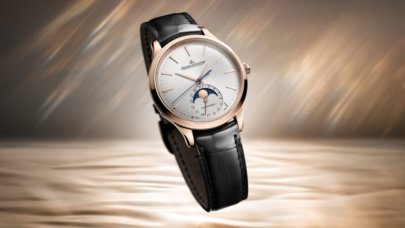 A Jaeger-LeCoultre Master Ultra Thin Moon watch with pink gold case, white dial, moonphase display, and black leather strap.