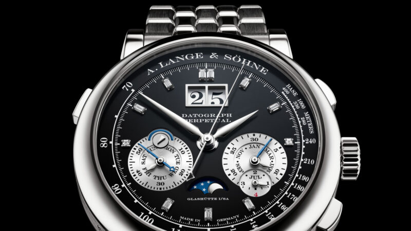 Close-up of an A. Lange & Söhne Datograph Perpetual watch with black dial, moonphase, and steel bracelet.