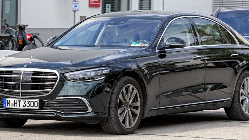 A black Mercedes-Benz S-Class sedan parked on a street with a German license plate.