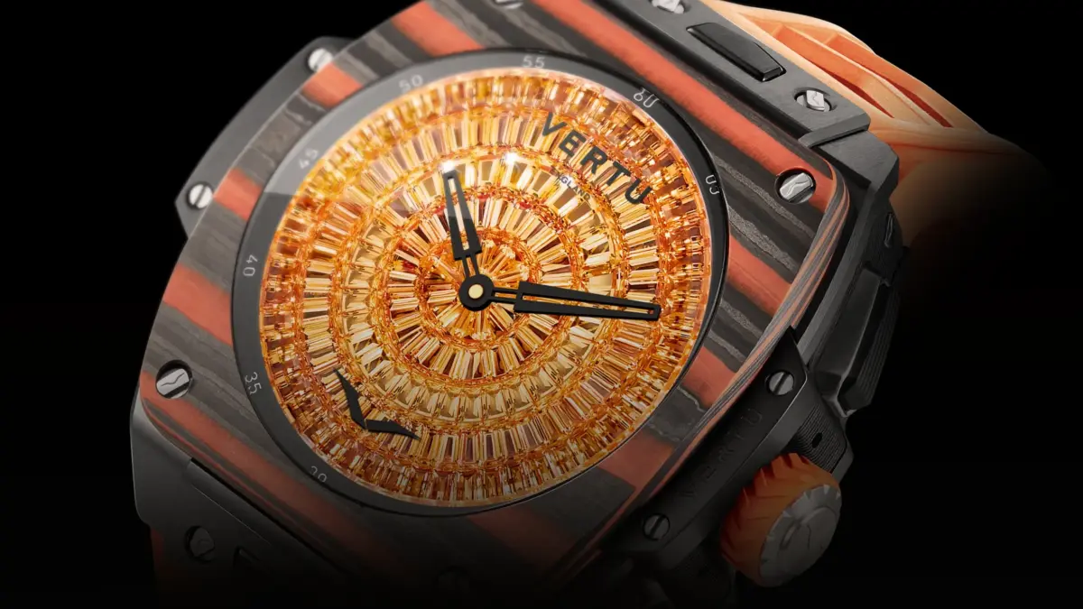 Close-up of a Vertu watch with a square case, orange and black striped band, and a crystal-studded gold dial.